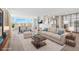 Bright living room with comfortable furnishings, stylish rug, and gorgeous water views from expansive windows at 174 Golden Gate Pt # 21, Sarasota, FL 34236