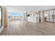 Bright and open living space featuring hardwood floors, a waterfront view, and contemporary design elements at 174 Golden Gate Pt # 21, Sarasota, FL 34236