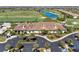 Elegant clubhouse exterior with tile roof, palm trees, and ample parking surrounded by a lush golf course at 18114 Gawthrop Dr # 201, Bradenton, FL 34211