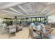 Elegant dining room with tables set for service and a view of the greenery at 18114 Gawthrop Dr # 201, Bradenton, FL 34211