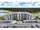 The exterior of a condo complex with covered parking, golf course, and lake in the background at 18114 Gawthrop Dr # 201, Bradenton, FL 34211