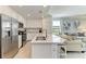 Modern kitchen with stainless steel appliances, white cabinetry, and an island with a sink and breakfast bar at 18114 Gawthrop Dr # 201, Bradenton, FL 34211