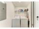 This small laundry room contains a washer, a dryer, and a wire rack for storage at 18114 Gawthrop Dr # 201, Bradenton, FL 34211