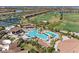 Luxurious community pool area featuring a waterfall, tropical landscaping, and ample lounge seating at 18114 Gawthrop Dr # 201, Bradenton, FL 34211