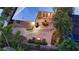 Aerial view of the backyard featuring a patio with dining, a fire pit, and lush landscaping under string lights at 1934 Bougainvillea St, Sarasota, FL 34239