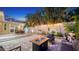 Inviting backyard with a brick patio, outdoor dining, and stylish furniture around a modern fire pit under string lights at 1934 Bougainvillea St, Sarasota, FL 34239