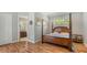 A bedroom with wood floors and a four poster wooden bed with a connected bathroom at 1934 Bougainvillea St, Sarasota, FL 34239