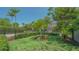 Well-manicured front yard with lush green grass, palm trees, mature trees, and partial view of the house at 1934 Bougainvillea St, Sarasota, FL 34239