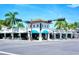 White retail building with blue awnings offering diverse options, complemented by palm trees and sunny skies at 1934 Bougainvillea St, Sarasota, FL 34239