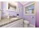Bright bathroom features lilac walls, granite counters, hexagon tile, and white vanity at 2004 19Th W St, Bradenton, FL 34205