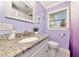Bright bathroom features lilac walls, granite counters, hexagon tile, and white vanity at 2004 19Th W St, Bradenton, FL 34205