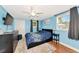 Cozy bedroom with blue walls, ceiling fan, and window overlooking a tree at 2004 19Th W St, Bradenton, FL 34205
