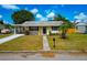 Single-story home showcasing curb appeal with a well-maintained lawn and a covered parking area at 2004 19Th W St, Bradenton, FL 34205