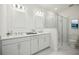 Bright bathroom with double vanity sinks, a walk-in shower, and marble flooring at 204 Eagleston Ln, Lakewood Ranch, FL 34240
