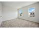 Bright bedroom with plush carpeting, a view of the neighborhood, and ample natural light at 204 Eagleston Ln, Lakewood Ranch, FL 34240