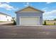 A detached two car garage with blue siding and a yellow accent above the door at 204 Eagleston Ln, Lakewood Ranch, FL 34240