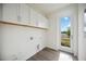 Laundry room with modern cabinetry, new door, and hardwood style flooring at 204 Eagleston Ln, Lakewood Ranch, FL 34240