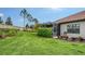 Landscaped backyard featuring a lush lawn, privacy hedge, and screened lanai, ideal for outdoor living at 229 Alento Ct, Nokomis, FL 34275