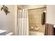Bathtub with shower, decorative turtle, and tiled wall with convenient soap and shampoo caddy at 229 Alento Ct, Nokomis, FL 34275