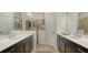Bathroom featuring double sink vanity with modern fixtures, tiled floor, and walk-in shower with glass partition at 229 Alento Ct, Nokomis, FL 34275