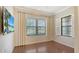 Bright bedroom with wood floors, a ceiling fan, and two windows at 229 Alento Ct, Nokomis, FL 34275