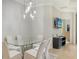Open dining area with contemporary glass table and seating under modern pendant lighting at 229 Alento Ct, Nokomis, FL 34275