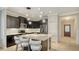 Modern kitchen features dark cabinets, stainless appliances, and a marble island with seating at 229 Alento Ct, Nokomis, FL 34275