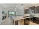 Open kitchen with dark cabinets, a large island with seating, and views into the living area at 229 Alento Ct, Nokomis, FL 34275
