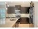 Modern kitchen features dark cabinets, stainless steel appliances, and tile flooring at 229 Alento Ct, Nokomis, FL 34275
