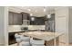 Modern kitchen features dark cabinets, stainless appliances, and a marble island with seating at 229 Alento Ct, Nokomis, FL 34275