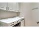 Laundry room with white cabinetry above modern washer and dryer at 229 Alento Ct, Nokomis, FL 34275