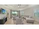 Bright living room with neutral furniture and view to patio at 229 Alento Ct, Nokomis, FL 34275