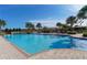 Community pool with clear blue water, lounge chairs, and palm trees, perfect for relaxation at 229 Alento Ct, Nokomis, FL 34275