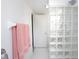 Bright bathroom with a glass block shower, white tile, and colorful towel accents at 2400 N Beach Rd # 1, Englewood, FL 34223