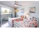 Inviting bedroom with floral bedding, beach themed decor, and a sunny balcony at 2400 N Beach Rd # 1, Englewood, FL 34223