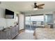 Cozy bedroom with a balcony overlooking ocean, a ceiling fan, and a wall-mounted TV at 2400 N Beach Rd # 1, Englewood, FL 34223