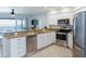 Bright kitchen features white cabinetry, stainless steel appliances, and a counter overlooking ocean views at 2400 N Beach Rd # 1, Englewood, FL 34223