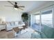Living room features a ceiling fan, comfortable seating, and sliding glass doors to the outside deck at 2400 N Beach Rd # 1, Englewood, FL 34223