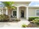 Charming front entrance with decorative columns, landscaping, and covered porch at 2808 124Th E Ave, Parrish, FL 34219