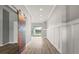 Inviting hallway featuring custom barn door and views of outdoor scenery at 2808 124Th E Ave, Parrish, FL 34219