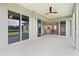 Large, open-air patio features multiple entry points, a ceiling fan, and seamless flow to the kitchen at 2808 124Th E Ave, Parrish, FL 34219