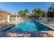 A clean community pool with clear water, lounge chairs, palm trees, and a white fence at 2808 124Th E Ave, Parrish, FL 34219