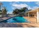 Sparkling blue swimming pool with sun loungers, surrounded by lush trees, and a covered patio at 2808 124Th E Ave, Parrish, FL 34219