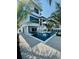 A modern pool and spiral staircase highlight a spacious backyard, framed by tropical plants at 2809 Avenue E, Holmes Beach, FL 34217