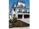 Beautiful three-story home featuring a modern design with balconies and dark wood garage doors at 2809 Avenue E, Holmes Beach, FL 34217