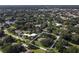 Aerial view showcases the home's location in a desirable neighborhood near a lake and wooded areas at 3010 E Forest Lake Dr, Sarasota, FL 34232