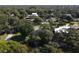 Overhead view of a wooded property with mature trees, surrounded by a tranquil pond at 3010 E Forest Lake Dr, Sarasota, FL 34232