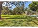 Expansive backyard with mature trees providing shade, leading to a screened in pool area at 3010 E Forest Lake Dr, Sarasota, FL 34232