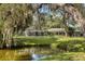 Backyard featuring a pond view, screened in lanai, and mature trees creating a relaxing retreat at 3010 E Forest Lake Dr, Sarasota, FL 34232