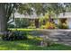 Charming home featuring lush landscaping and a circular driveway, creating curb appeal at 3010 E Forest Lake Dr, Sarasota, FL 34232